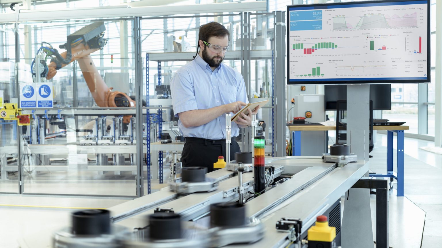Engineer testing a robotic production simulator in robotics research facility