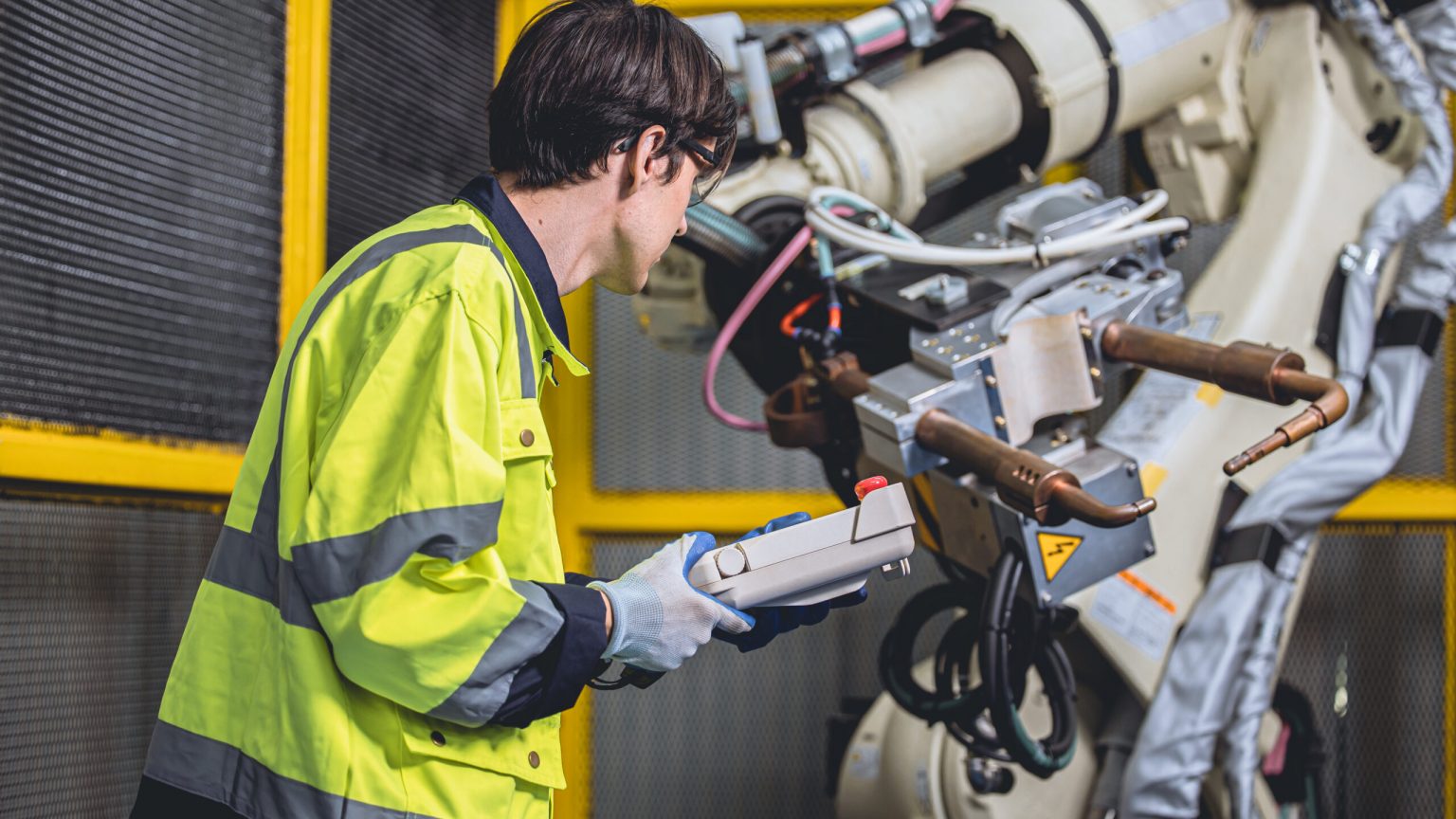 lead engineer working in advanced technology automation factory service checking program robot welding arm